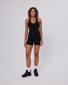 Woman wearing a black athletic outfit on a white background