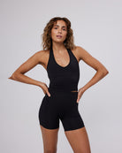 Woman wearing a black athletic outfit on a plain background